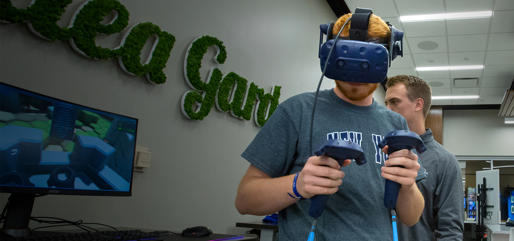 A person wearing a VR headset and interacting with a game at the Idea Garden